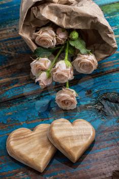 two wooden heart and bouquet of fresh cut roses