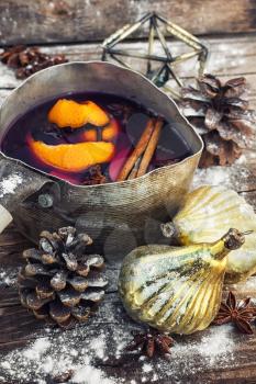 The old pot of fragrant mulled wine on the background of Christmas decorations