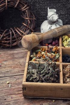 Dried medicinal herbs in wooden box on  background of licorice