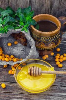 Still life with tea with fresh sea-buckthorn berries in rustic style.