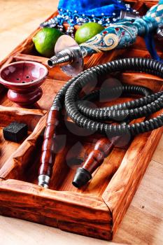 Wooden box with hookah smoking accessories and fruits of lime