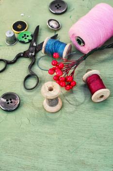 Thread for sewing,buttons and decoration on wooden background.