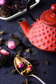 Red teapot and spoon with the varieties of tea leaves