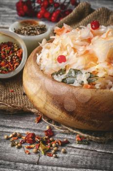 Fermented cabbage with spices in wooden tub in rustic style