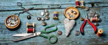 Sewing tools scissors,threads and buttons on old vintage background