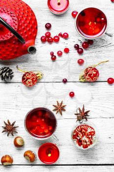 Kettle,cranberry tea and Christmas toy on light background