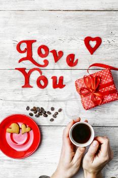 Woman's hands with gift box and Cup of coffee