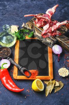 Raw meat on the rib of lamb in hot spices on the kitchen board.Copy space