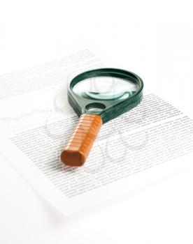Magnifier lies on a piece of paper, studio shot, photo with shadow, non-isolated