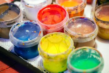 Colorful acrylic paints in plastic cans. Macro photo