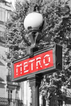 Street sign at the entrance to the Paris Metro, red banner on the street lamp, tonal correction effect