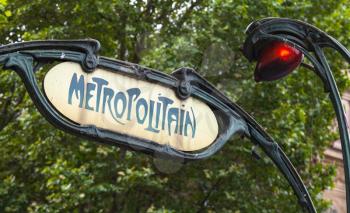 Art-Deco styled Street sign with red light at the entrance to the Paris Metro