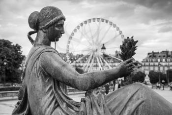 Paris, France - August 7, 2014: Maillol Aristide, bronze woman sculpture and ferris wheel in Tuileries park