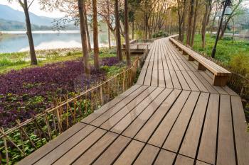 Wooden pathway on the coast. Walking around famous West Lake park in Hangzhou city center, China