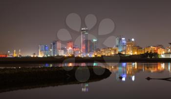 Night city skyline, shining lights and reflections in water. Manama, the Capital of Bahrain Kingdom, Middle East