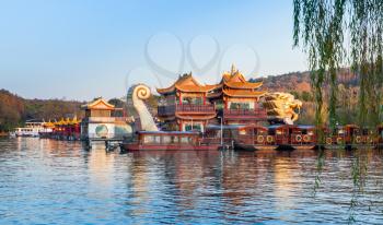 Hangzhou, China - December 5, 2014: Traditional Chinese wooden pleasure boats and Dragon ship are moored on the West Lake. Famous park in Hangzhou city center, China