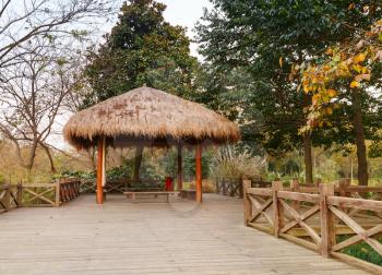 Wooden pathway and traditional Chinese gazebo. Walking around famous West Lake park in Hangzhou city, China