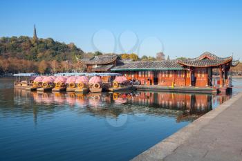 Chinese recreation boats are moored on the West Lake coast. Famous park in Hangzhou city, China