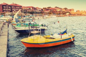 Small wooden boats in Nesebar, ancient historical town, Black Sea coast, Bulgaria. Vintage retro stylized photo with tonal correction filter, instagram style 