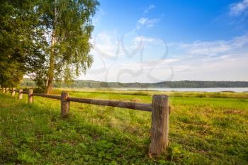 Wooden fence on the lake coast, Russian landscape