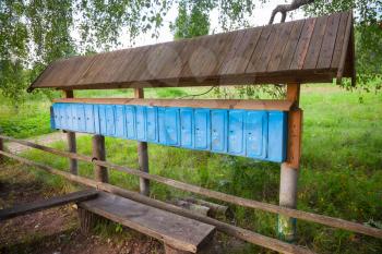 Old rusted blue mailboxes in a row, small Russian village 