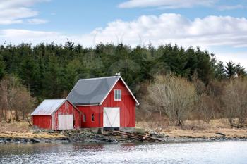 Traditional Norwegian red wooden barns on the sea coast