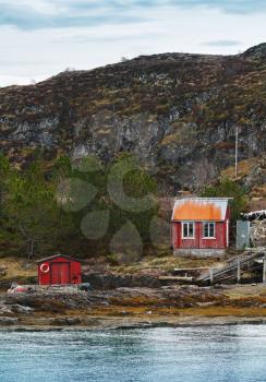 Old Norwegian red wooden houses on rocky coast