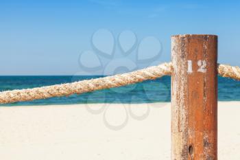 Beach border railing with rope in the summer day