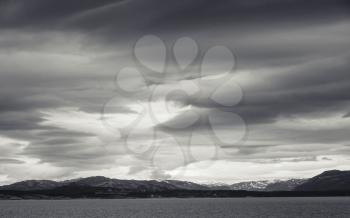 Monochrome Norwegian coastal landscape with sea and dramatic stormy sky
