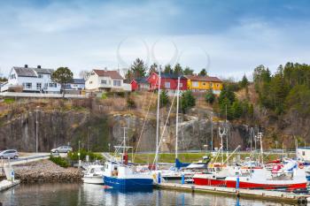 Small Norwegian village, wooden houses and moored fishing boats on the North sea coast 