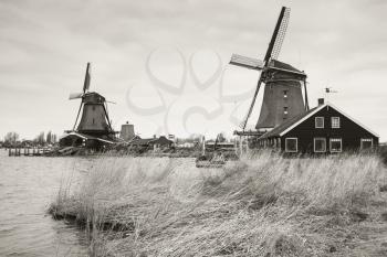 Windmills in Zaanse Schans town. It is one of the popular tourist attractions of the Netherlands. Retro stylized sepia toned monochrome photo