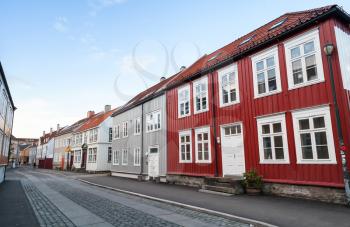 Traditional Scandinavian wooden houses stand along the street. Trondheim, Norway