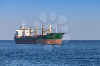 Green bulk carrier with red waterline. Empty cargo ship sails on the Black Sea