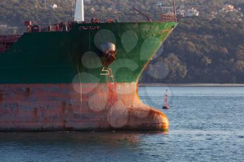 Green bow with red waterline of big industrial cargo ship