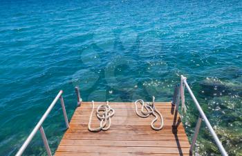 Nautical ropes lay on small wooden pier. Zakynthos island, Greece