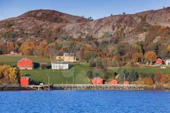 Traditional Norwegian coastal village landscape, colorful wooden houses and barns on seacoast