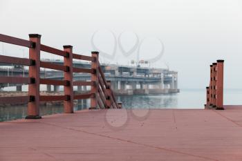 Empty red wooden pier in foggy evening, Busan, South Korea
