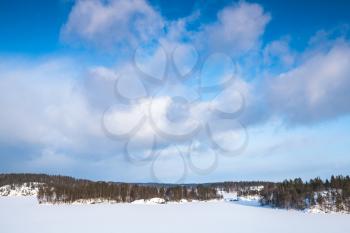 Frozen Saimaa lake under cloudy sky. Rural winter landscape, Finland
