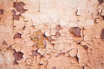 Grunge metal wall with peeling paint and rust spots, close-up background photo texture