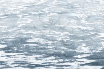 Ice with show on frozen river in winter season, natural background photo texture