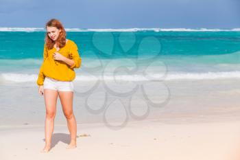 Pretty Caucasian teenage girl walking on the beach in Dominican Republic