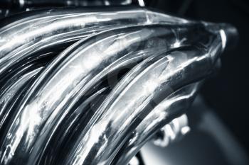 Bent air exhaust pipes. Shiny motor parts, V12 engine fragment, closeup photo with selective focus
