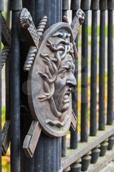 Medusa face, profile. In Greek mythology it was a monster, a Gorgon, winged human female with living snakes in place of hair. Decorative fence of Summer Garden, built in 1825, St.Petersburg, Russia