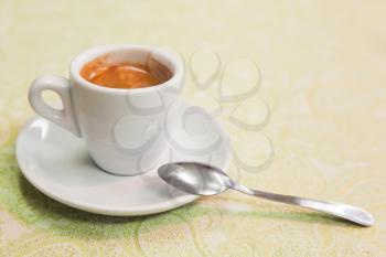 Freshly brewed espresso coffee in white cup stands on table. Closeup photo with selective focus