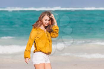 Beautiful Caucasian teenage girl walking on the ocean coast in Dominican Republic