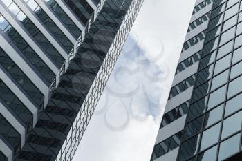 Abstract modern architecture background, office towers made of glass and steel under cloudy sky