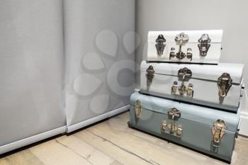 Decorative boxes with retro locks as an interior decoration stand in a corner of empty room