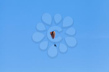 Paraglider in blue sky, ultralight aircraft created on the basis of a parachute and an engine with propeller 