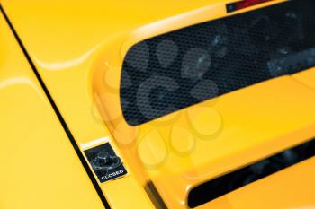 Luxury yellow roadster fragment. Hood lock. Italian car design