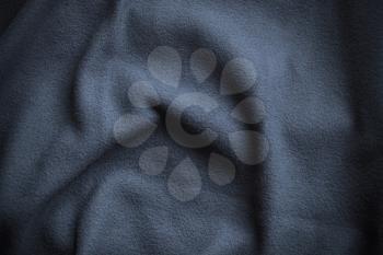 Texture of blue fleece, soft napped insulating fabric made from polyester, wavy pattern